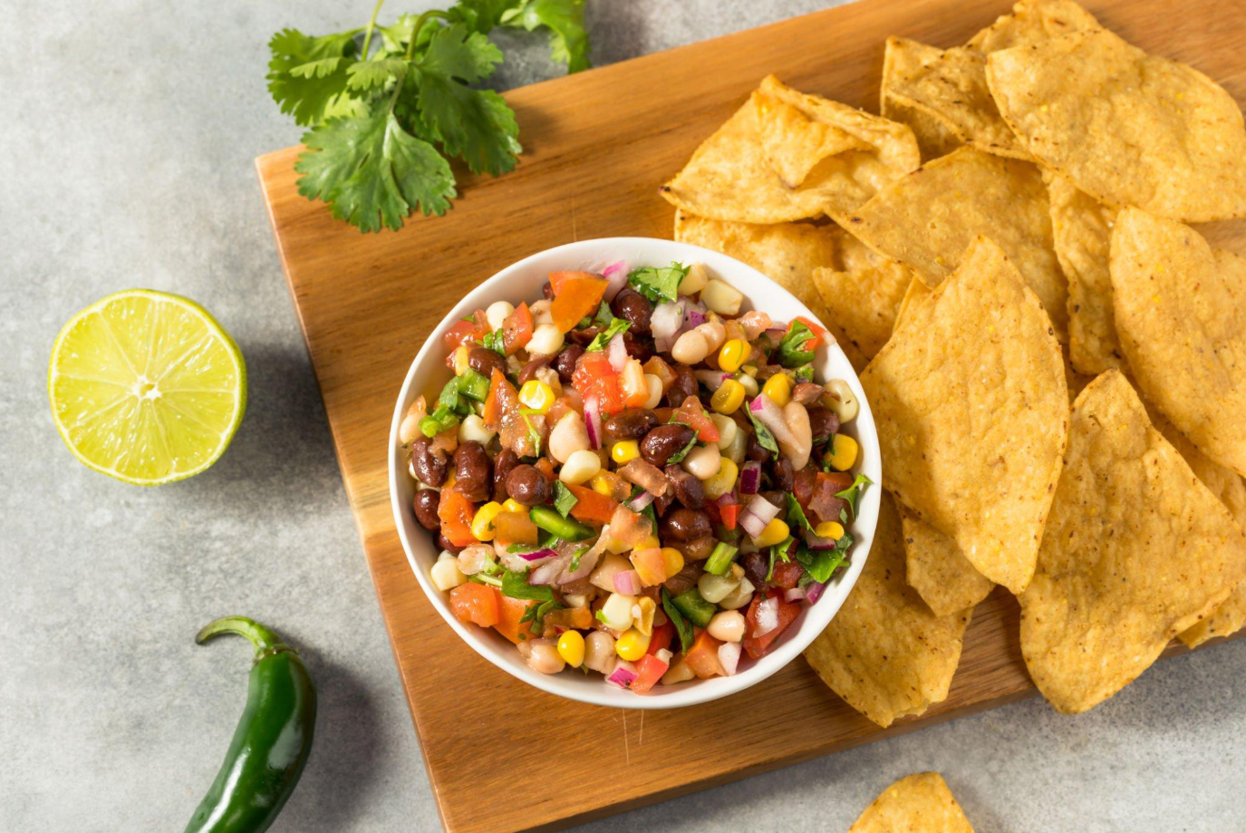 Step-by-step preparation of Chipotle Corn Salsa, showcasing chopping and mixing of ingredients.